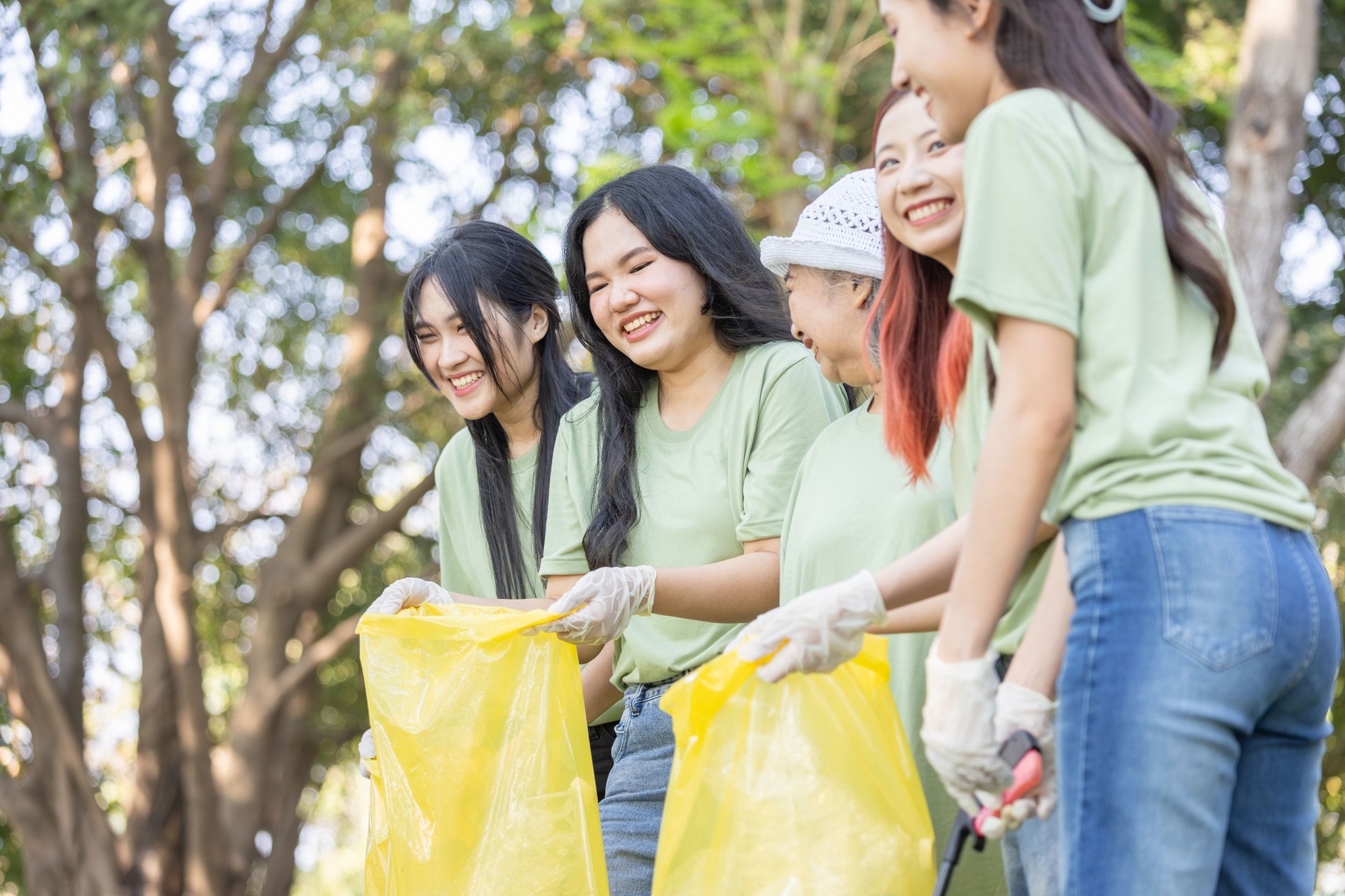 Cheerful Group of Volunteers Engaged in Cleanup Activity, Eco Volunteers Collecting Plastic Waste in Park, Teamwork for a Greener Planet, Female Volunteers Picking Up Trash