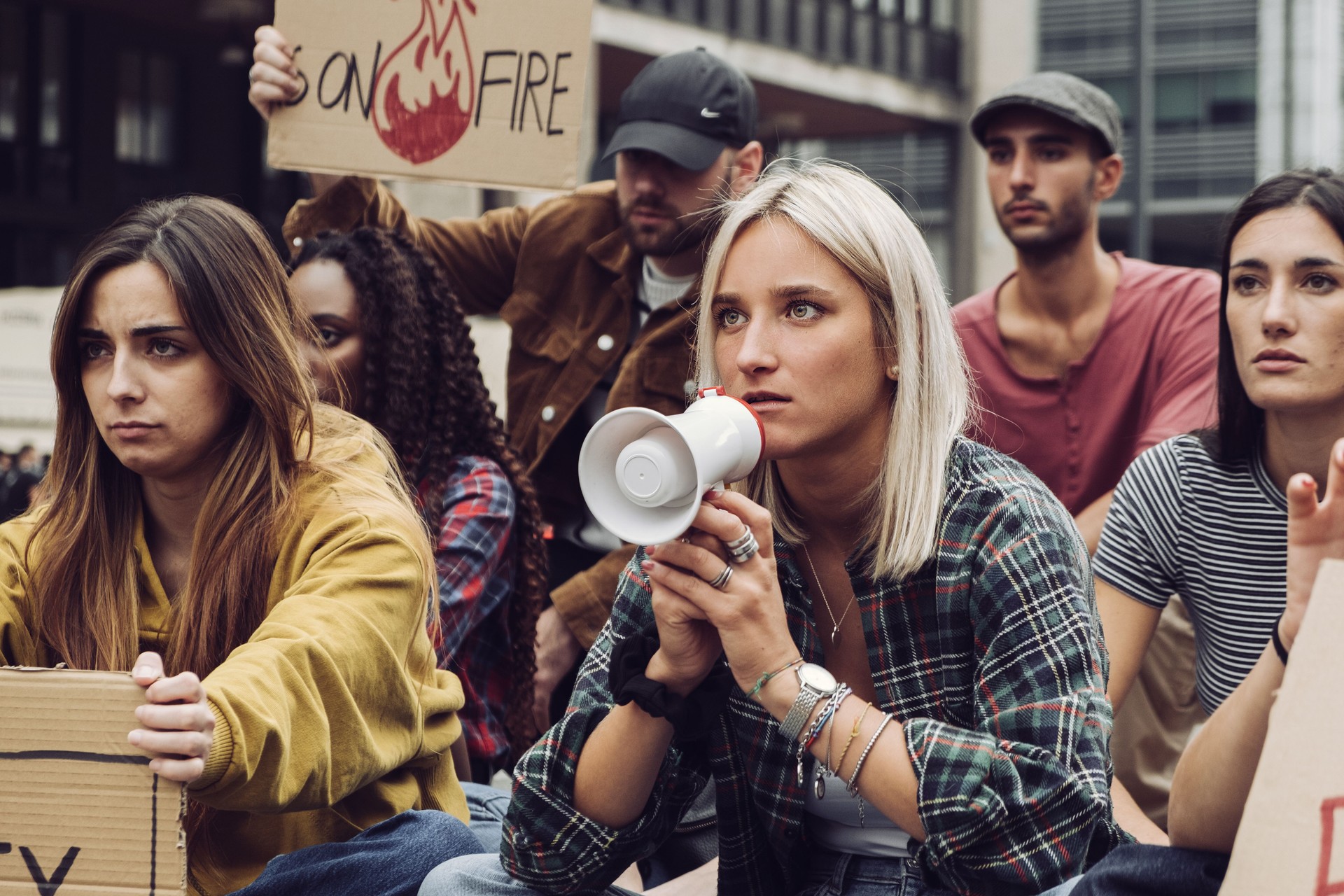 young protester sit-in - group of generation z people protesting against global warming
